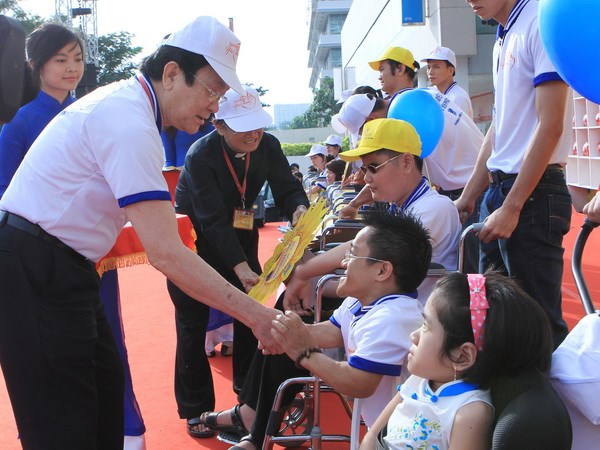 Chủ tịch nước Trương Tấn Sang thăm hỏi và tặng quà người khuyết tật có thành tích đặc biệt trong học tập và cuộc sống. (Ảnh: Nguyễn Khang/TTXVN)
